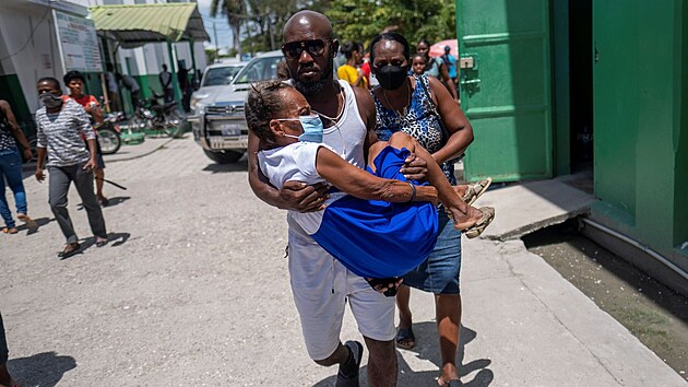 Příbuzní nesou do nemocnice ve městě Les Cayes zraněnou ženu. (16. srpna 2021)