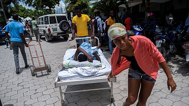 Lidé přesouvají zraněnou ženu do nemocnice ve městě Les Cayes. (16. srpna 2021)