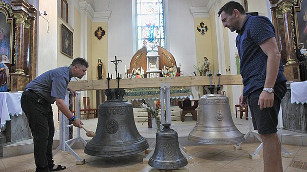 Šilheřovický farář  Jakub Dominik Štefík (vlevo) zkouší zvuk zvonu navráceného po 79 letech z německého Kolína nad Rýnem. Přihlíží starosta obce Radek Kaňa. (12. srpna 2021)