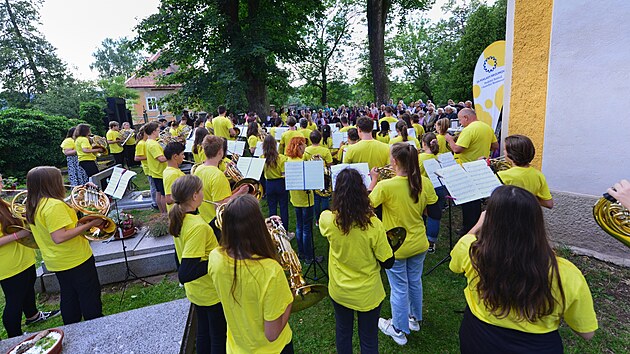 Účastníci a lektoři letních hornových kurzů zahráli u kostela sv. Michaela ve Vernéřovicích (4. 8. 2021).