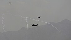 Americké vojenské helikoptéry Black Hawk létají nad Kábulem. Bojovníci Talibanu...