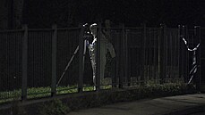 Policista ve forenzn�m obleku vy�et�uje m�sto st�elby, kter� se odehr�la v...