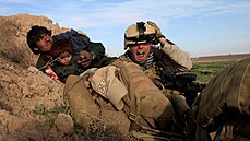 Americký voják chrání afghánského mue s díttem ped palbou Tálibánu v...
