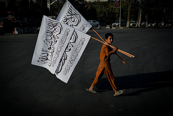 Afghánský chlapec prodává bílou vlajku Islámského emirátu Afghánistán, která s...