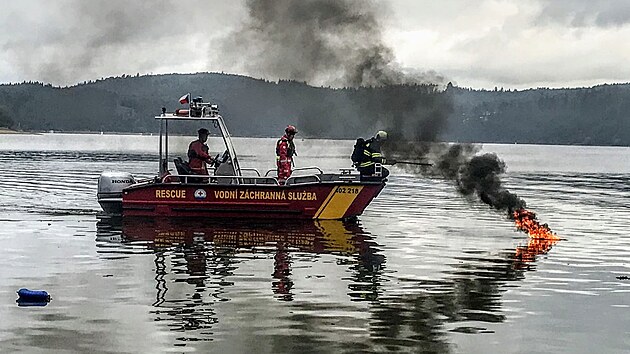 Hořící laminátový člun museli v kempu Radava uhasit hasiči. Pomáhali jim členové vodní záchranné služby.