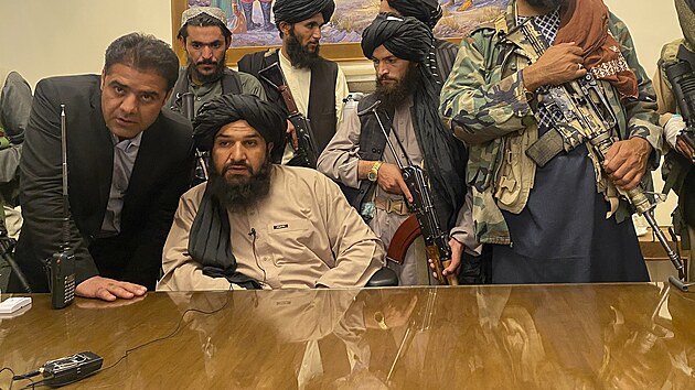 Tálibánští bojovníci pózují před fotografy v kanceláři afghánského prezidenta, který před nimi uprchl ze země. (15. srpna 2021)