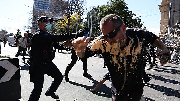 Účastníka demonstrace proti protiepidemickým opatřením v australském Melbourne pokryla štiplavá pěna z pepřového spreje. (21. srpna 2021)