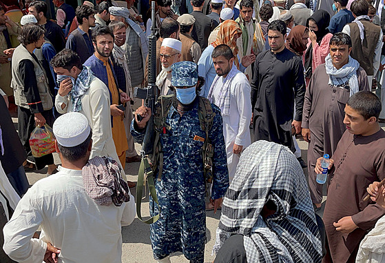 len hnutí Tálibán stojí na strái mezi davy lidí, kteí procházejí ulicemi...