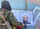 Tálibántí bojovníci stojí u portrétu mully Hajbatulláha Achúndzáda. (26. srpna...