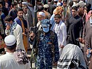 len hnutí Tálibán stojí na strái mezi davy lidí, kteí procházejí ulicemi...