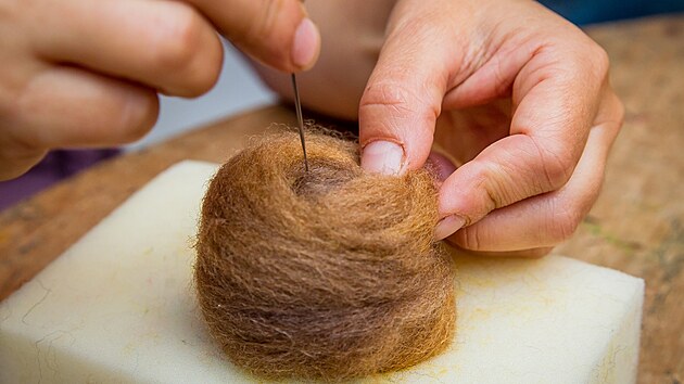 Ostr� jehla se zp�tn�mi h��ky proj�d� chom��em ov�� vlny. Pr�v� na pohled nepatrn� dr�ky po stran�ch zachyt�vaj� vl�kna. T�m, �e vlnu prop�chnete, se zachycen� vl�kna spletou.