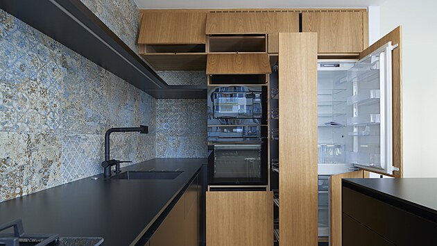 Kuchyňská linka vyrobená na míru využívá dokonale prostor výklenku. Výsuvná spíž je přístupná z obou stran.