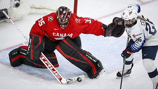 Kanadsk brankka Ann-Renee Desbiensov (vlevo) zasahuje ped americkou hokejistkou Kendall Coyneovou Schofieldovou.