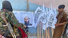 Tálibánští bojovníci stojí u portrétu mully Hajbatulláha Achúndzáda. (26. srpna...