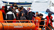 Migranti ekají na vylodní z plavidla panlské pobení stráe v pístavu na...