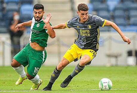 Mohammad Abu Fani (vlevo) z Maccabi Haifa a Guus Til z Feyenoordu bojují o mí.
