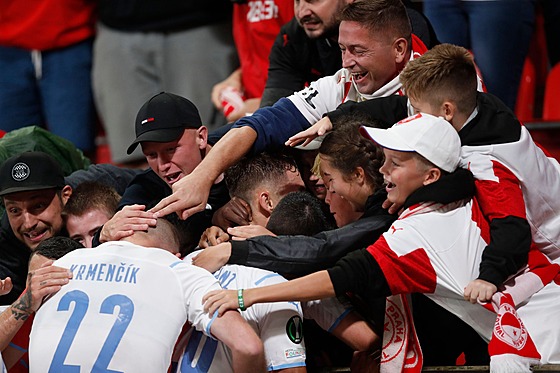 Fanouci Slavie objímají stelce tetího gólu Ivana Schranze.