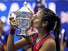 Britka Emma Raducanuová líbá trofej pro ampionku US Open.