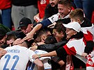 Fanouci Slavie objímají stelce tetího gólu Ivana Schranze.