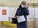 ena se pipravuje vhodit volební lístky do urny v jedné z moskevských...