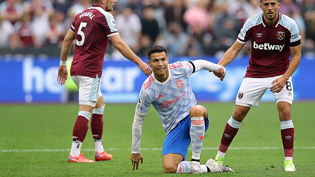 Cristiano Ronaldo (uprosted) z Manchesteru United se zved z trvnku, v pozad stoj Vladimr Coufal z West Hamu.