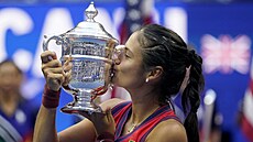 Britka Emma Raducanuová líbá trofej pro šampionku US Open.