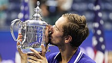 Rus Daniil Medveděv líbá trofej pro šampiona US Open.