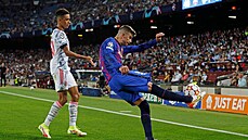 Gerard Piqué z Barcelony odkopává balon ped Jamalem Musialou z Bayernu.