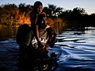 Migrant s díttem pekrauje eku Rio Grande, aby se dostal do Texasu. (23....