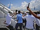 Haiané deportovaní z USA se snaí dostat zpt na palubu letadla a znovu se...
