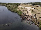 Migranti pekraují eku Rio Grande, aby se dostali do Texasu. (21. záí 2021)