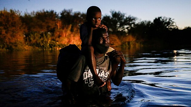 Migrant s dttem pekrauje eku Rio Grande, aby se dostal do Texasu. (23. z 2021)