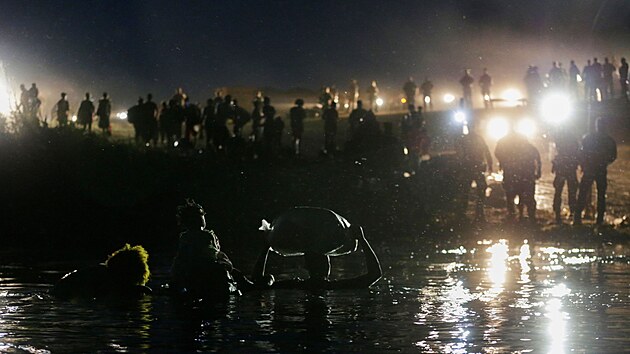 Migranti pekrauj eku Rio Grande, aby se dostali do Texasu. (23. z 2021)