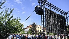 Lidé sledují na velkoploné obrazovce v nedaleké zahrad bohoslubu ve...