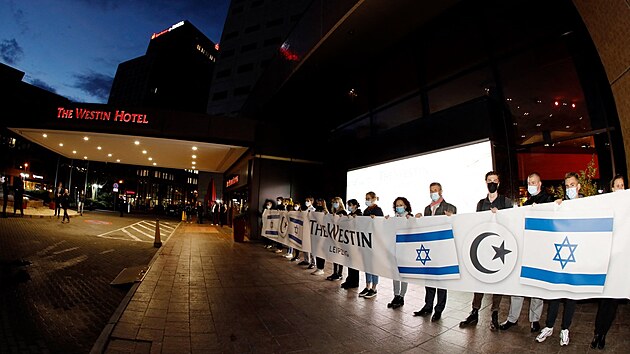 Ped hotelem Westin se konala akce na podporu idovskho hudebnka Gila Ofarima. Zamstnanci hotelu si pipravili transparent s izraelskou vlajkou a islmskm plmscem. (5. jna 2021)