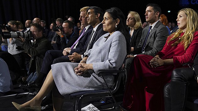 Britská Konzervativní strana uspořádala výroční konferenci. Na snímku poslouchá projev premiéra Borise Johnsona ministryně vnitra Priti Patelová (v popředí), ministr financí Rishi Sunak (vedle ní) a Johnsonova žena Carrie. (v červeném, 6. října 2021)