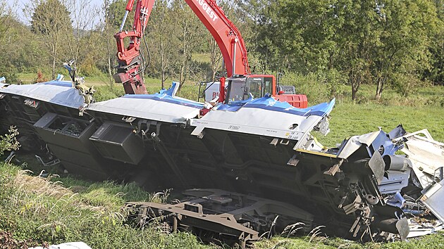Hydraulické nůžky rozstřihávají vagon, který zůstal po tragické srážce rychlíku s osobním vlakem letos v srpnu u Milavčí na Domažlicku nepojízdný. (4. 10. 2021)