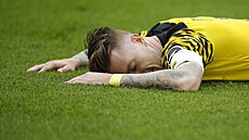 Zklamaný kapitán Borussie Dortmund, Marco Reus, leí na trávníku po zahozené...