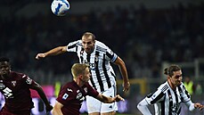 Kapitán Juventusu, Giorgio Chiellini, si naskakuje na letící míč. Před ním...