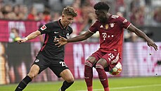 Jesper Lindström (vlevo) z Frankfurtu sleduje balon, který má Alphonso Davies z...