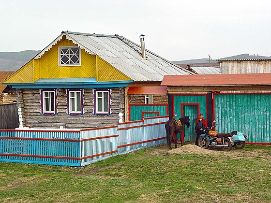 Motorka Ural na Urale. Na přední stěnu domu už nezbyla bílá barva.