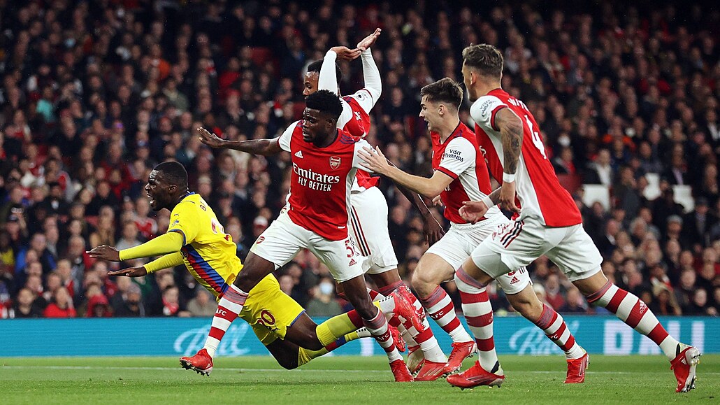 Christian Benteke z Crystal Palace letí k zemi po zákroku Thomase z Arsenalu.