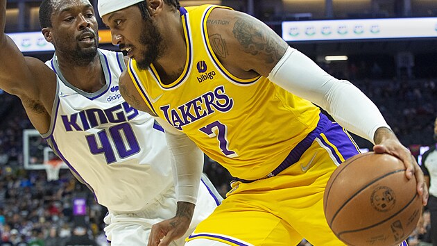 Carmelo Anthony (7) z Los Angeles Lakers najd ke koi Sacramenta kolem Harrisona Barnese.