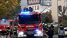 Kvůli požáru podkrovního bytu evakuovali hasiči celý obytný dům v Karlových...