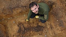 Archeolog Petr Krištuf u odkrytého hrobu kosterního nálezu člověka.