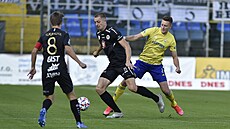 Hradecký Daniel Va�ulín vede mí� p�ed dotírajícím zlínským hrá�em v utkání 11....