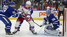 Filip Chytil z New York Rangers se pokouí prosadit ped brankou Toronta.