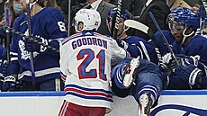 Barclay Goodrow z New York Rangers uklízí na stídaku Toronta Justina Holla.