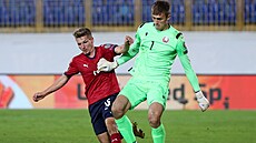 eský fotbalista Michal Sadílek dotírá na bloruského gólmana Pavla Pavjuenka.