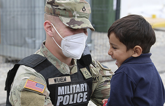 Americký voják s malým Afgháncem na základn Liya v Kosovu (1. íjna 2021)
